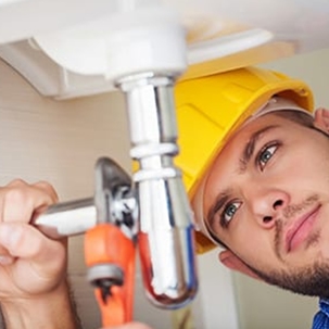 plumber fixes a pipe