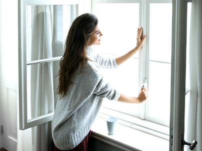 woman opens a large window